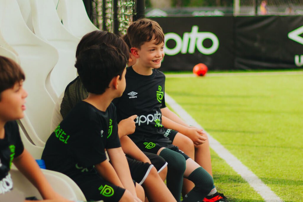 crianças conversando durante partida de futebol