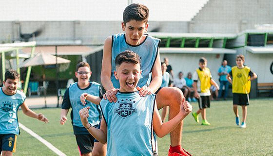 crianças comemorando durante partida de futebol