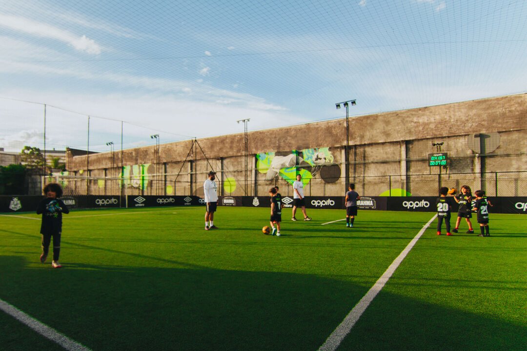 crianças jogando futebol em campo