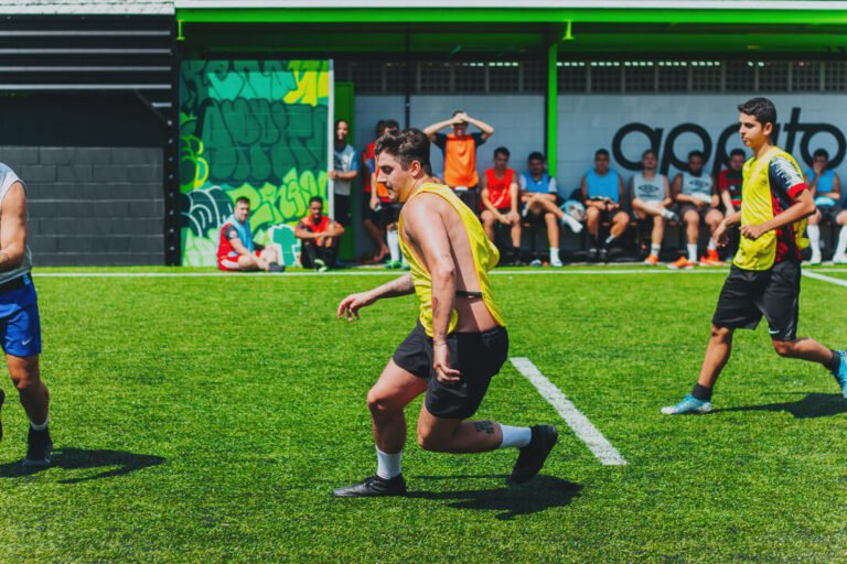 jogadores jogando futebol no campo sintético
