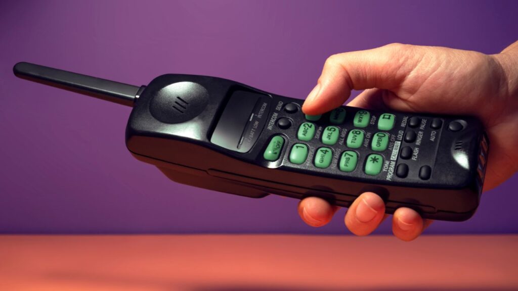 pessoa segurando telefone antigo