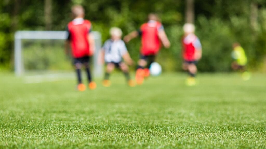 crianças jogando futebol no campo