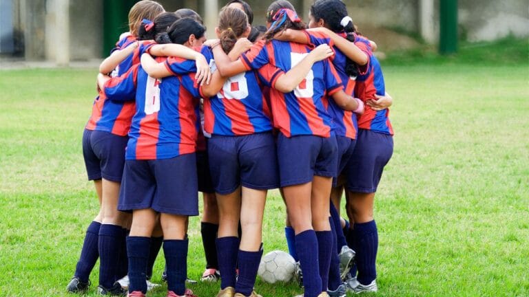 jogadoras reunidas no campo de futebol