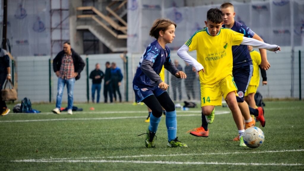 crianças durante partida de futebol