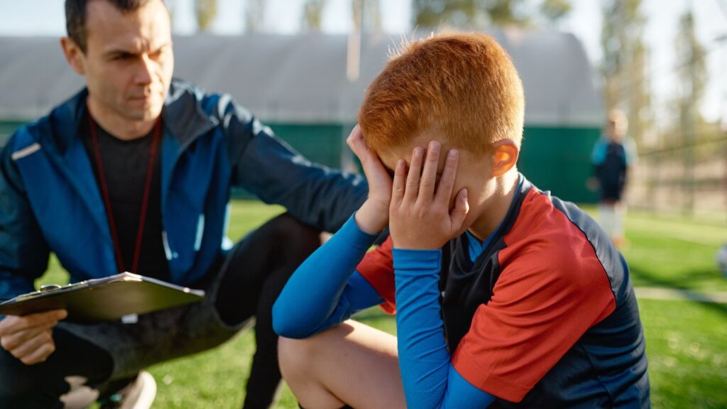 atleta sendo consolado pelo técnico