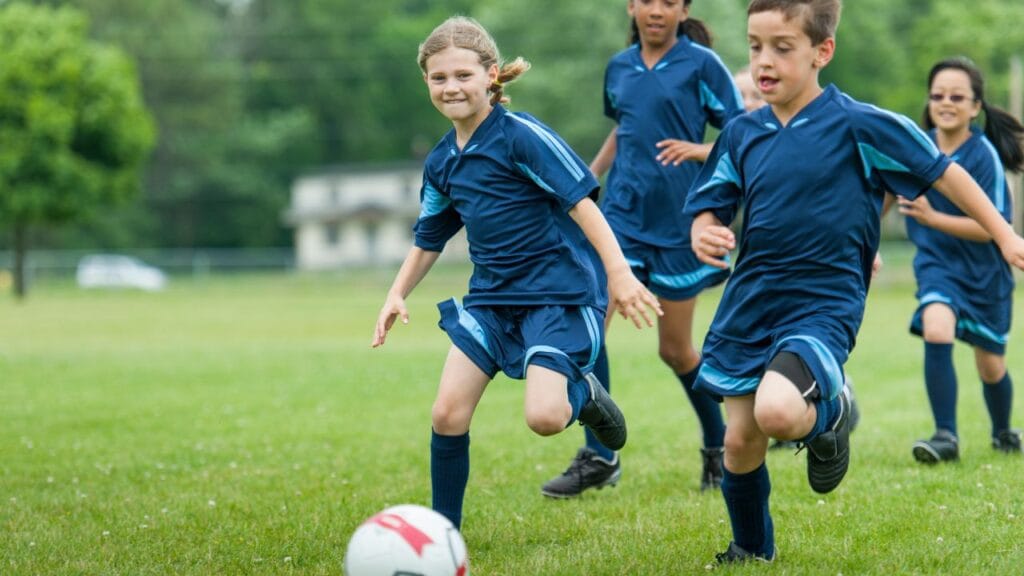 crianças jogando futebol sorrindo