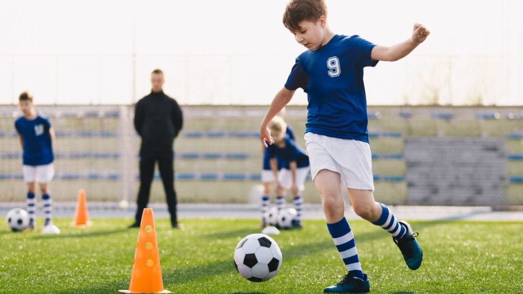 criança treinando futebol